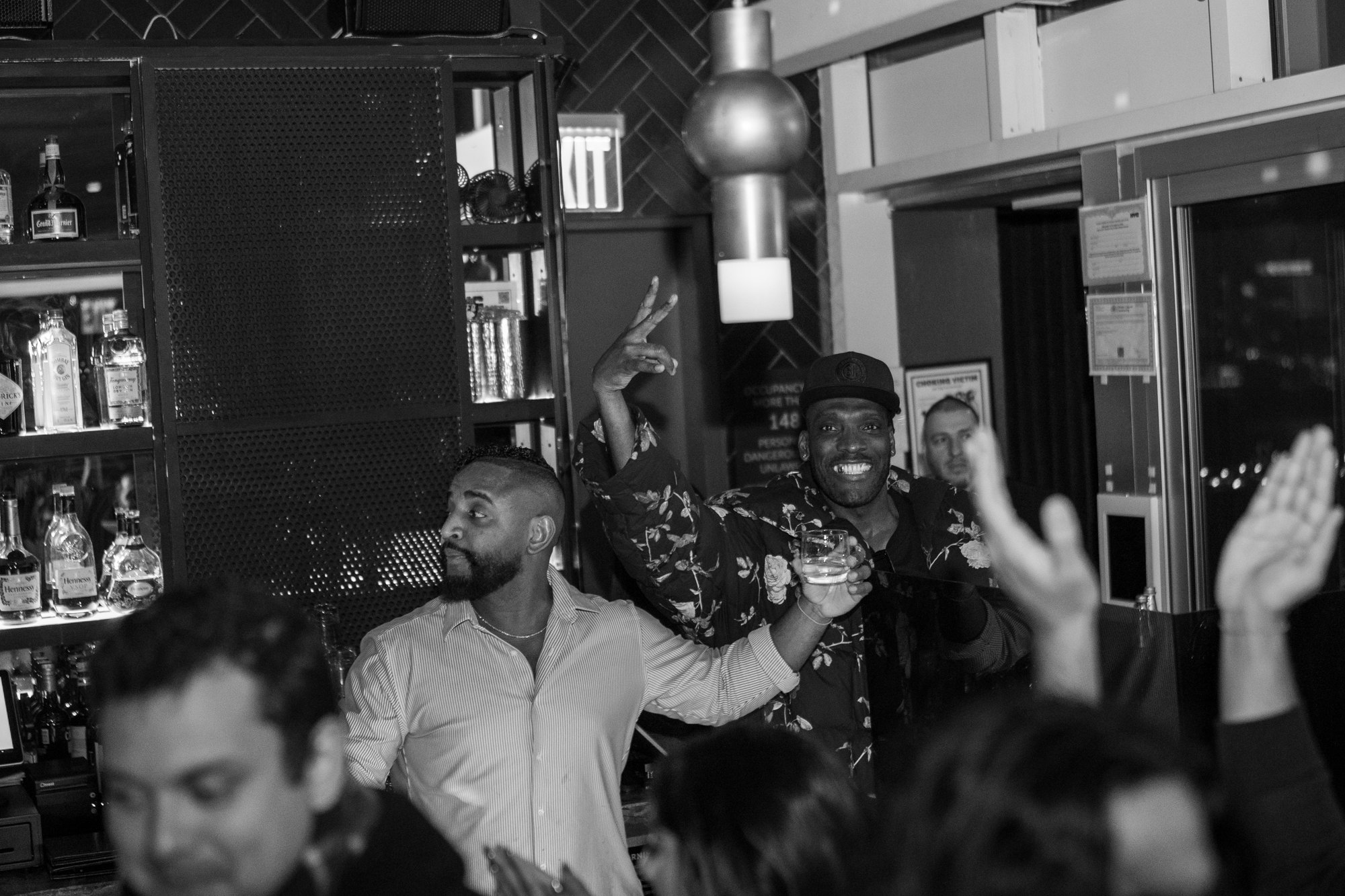 A guest leaping at the bar with hands up at The Jimmy