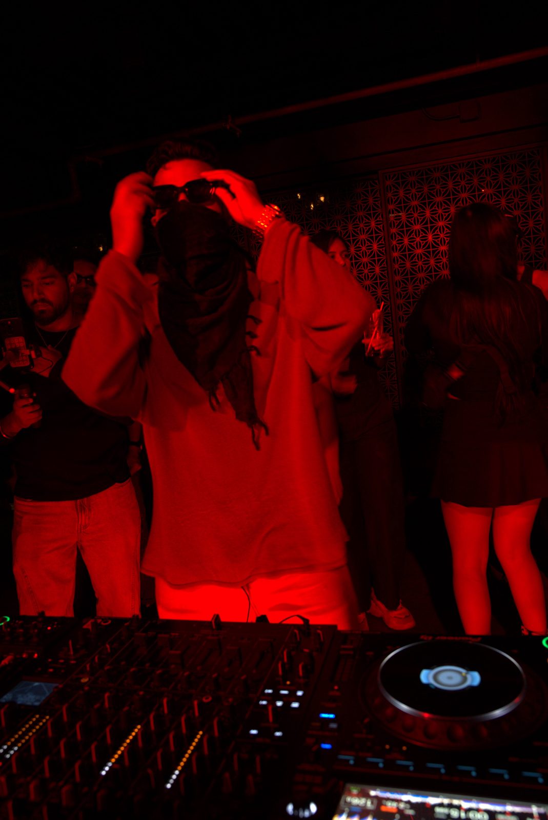 SHNKR adjusting his sunglasses behind the decks at 16 Sola